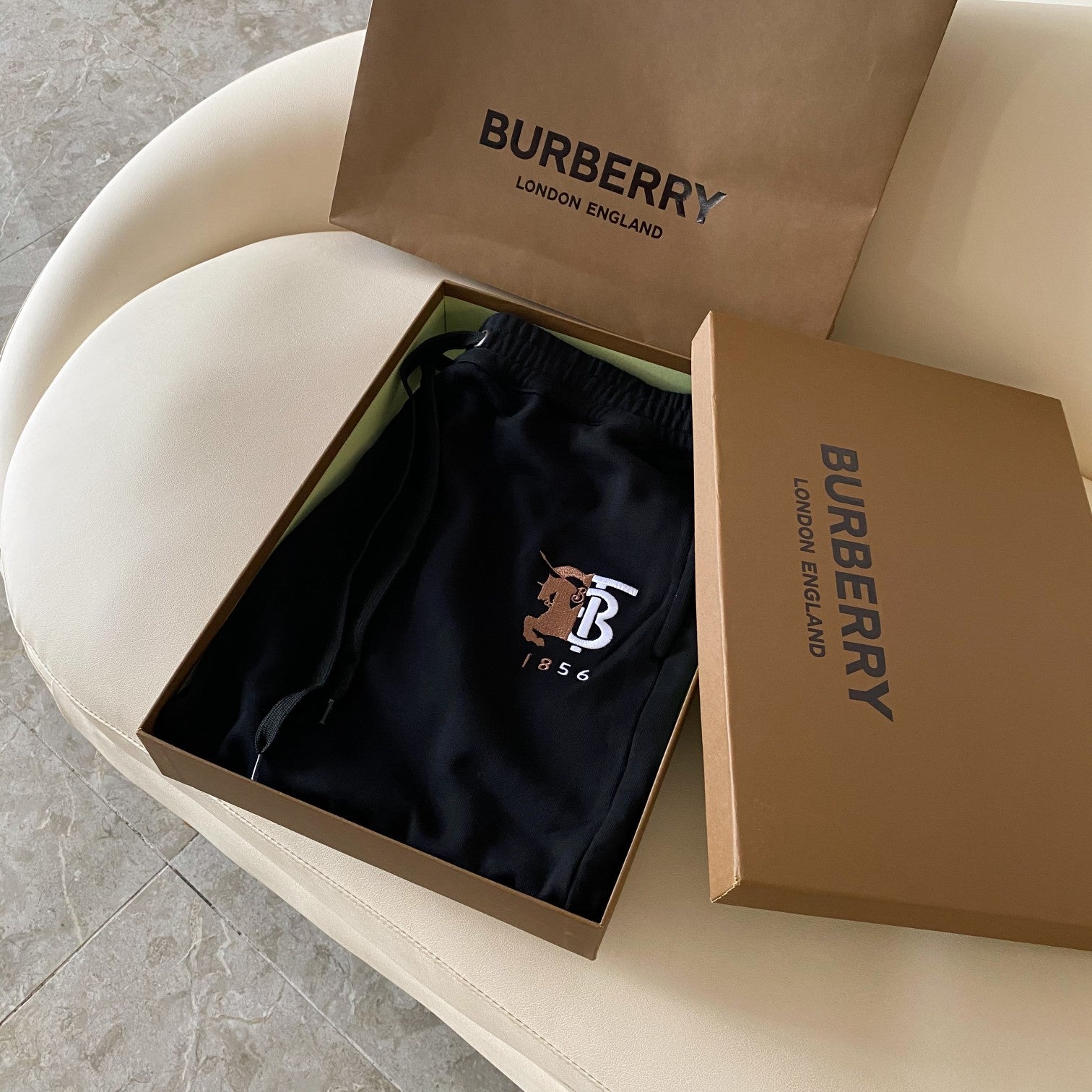 Black Burberry drawstring shorts folded in an open gift box