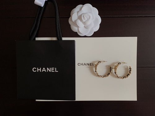 Gold-tone chain hoop earrings with black enamel accents on display card