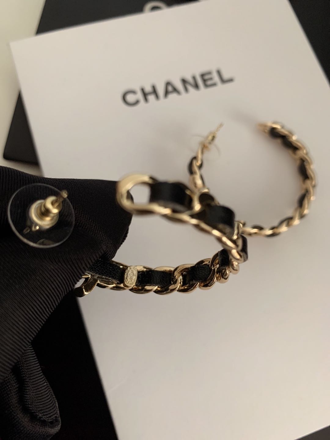 Gold-tone chain hoop earrings on CHANEL jewelry card