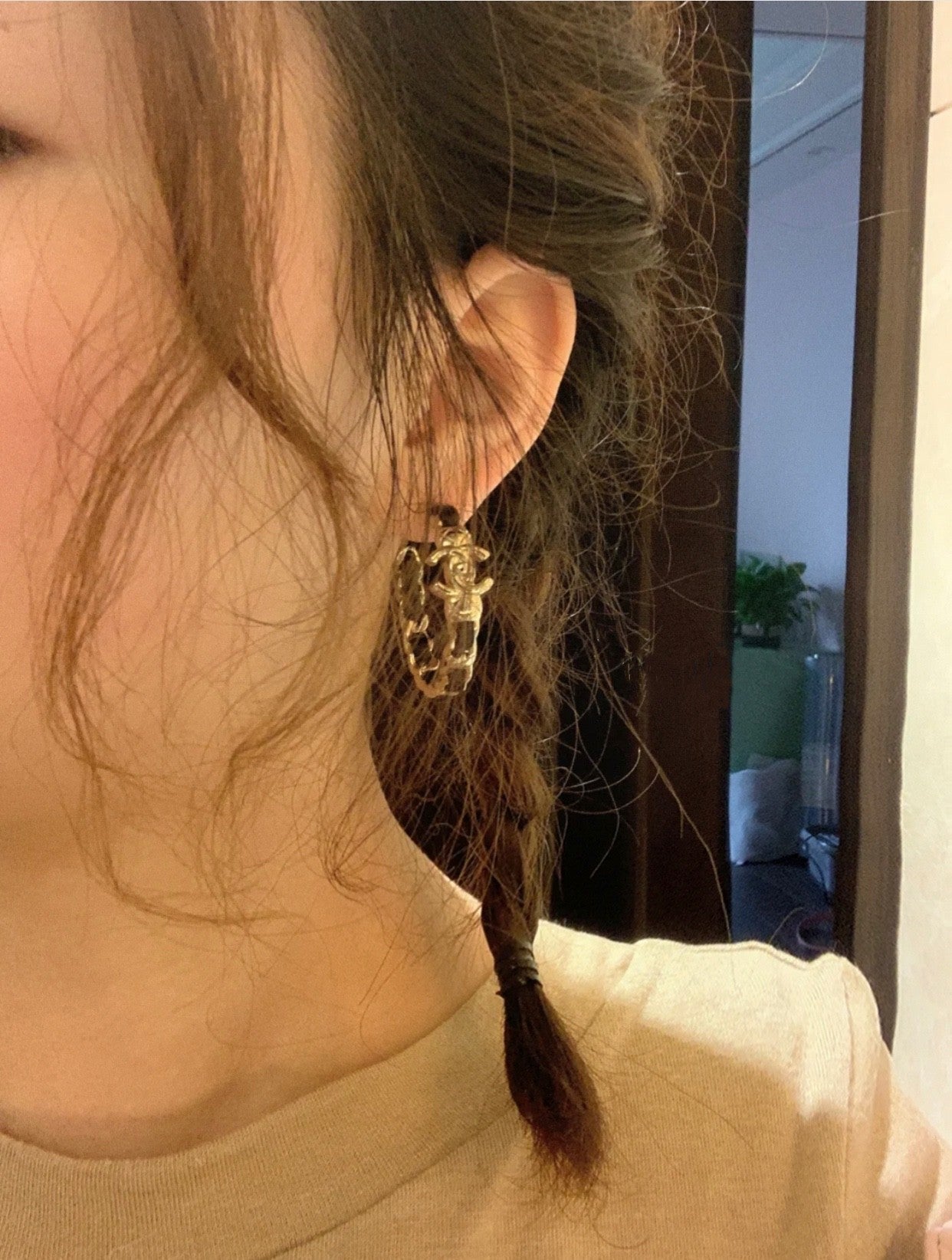Gold-tone chain hoop earrings with black accents worn