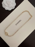 Gold-tone chain bracelet with round logo medallion charm and small heart clasp