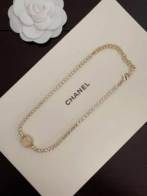 Gold-tone chain bracelet with round logo medallion charm and small heart clasp