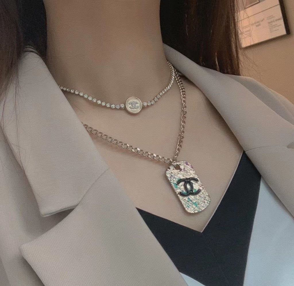 Silver-tone layered necklace with round logo choker and long chain pendant charm