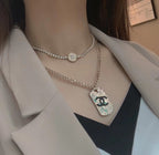 Silver-tone layered necklace with round logo choker and long chain pendant charm