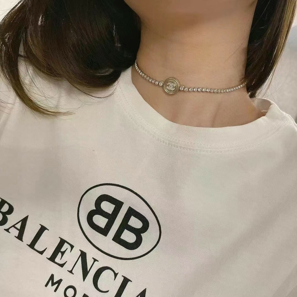 Rhinestone choker necklace with round logo medallion on a thin chain band