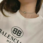 Rhinestone choker necklace with round logo medallion on a thin chain band