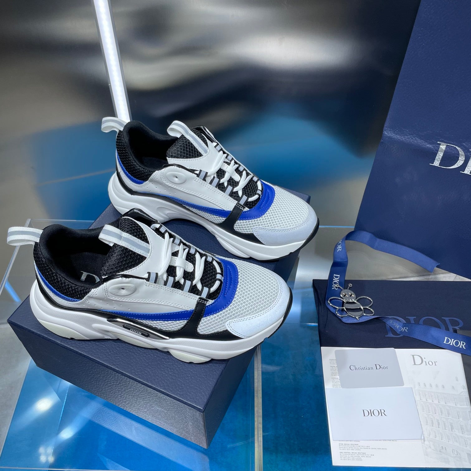 Dior unisex sneakers pair, white upper with black laces and blue side stripe