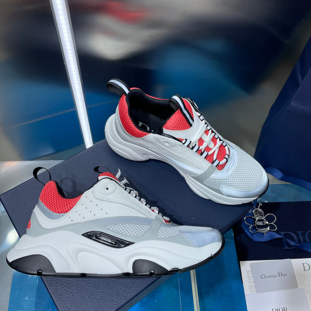 White lace-up sneakers with red mesh panels, black accents, and chunky sole.
