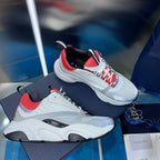 White lace-up sneakers with red mesh panels, black accents, and chunky sole.