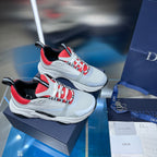 Pair of white lace-up sneakers with red panels and black trim on display.