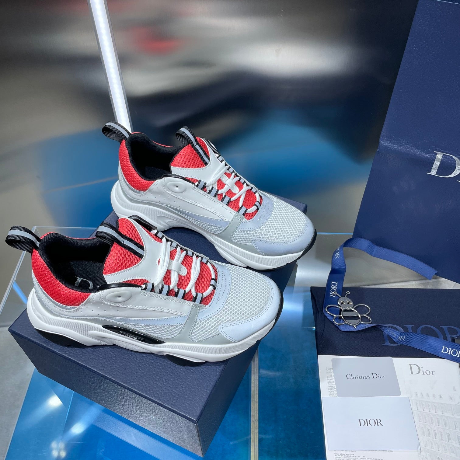 Pair of white lace-up sneakers with red panels and black trim on display.