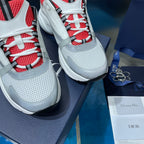 Close-up of white sneakers with red-and-black eyelets and blue-and-white laces.