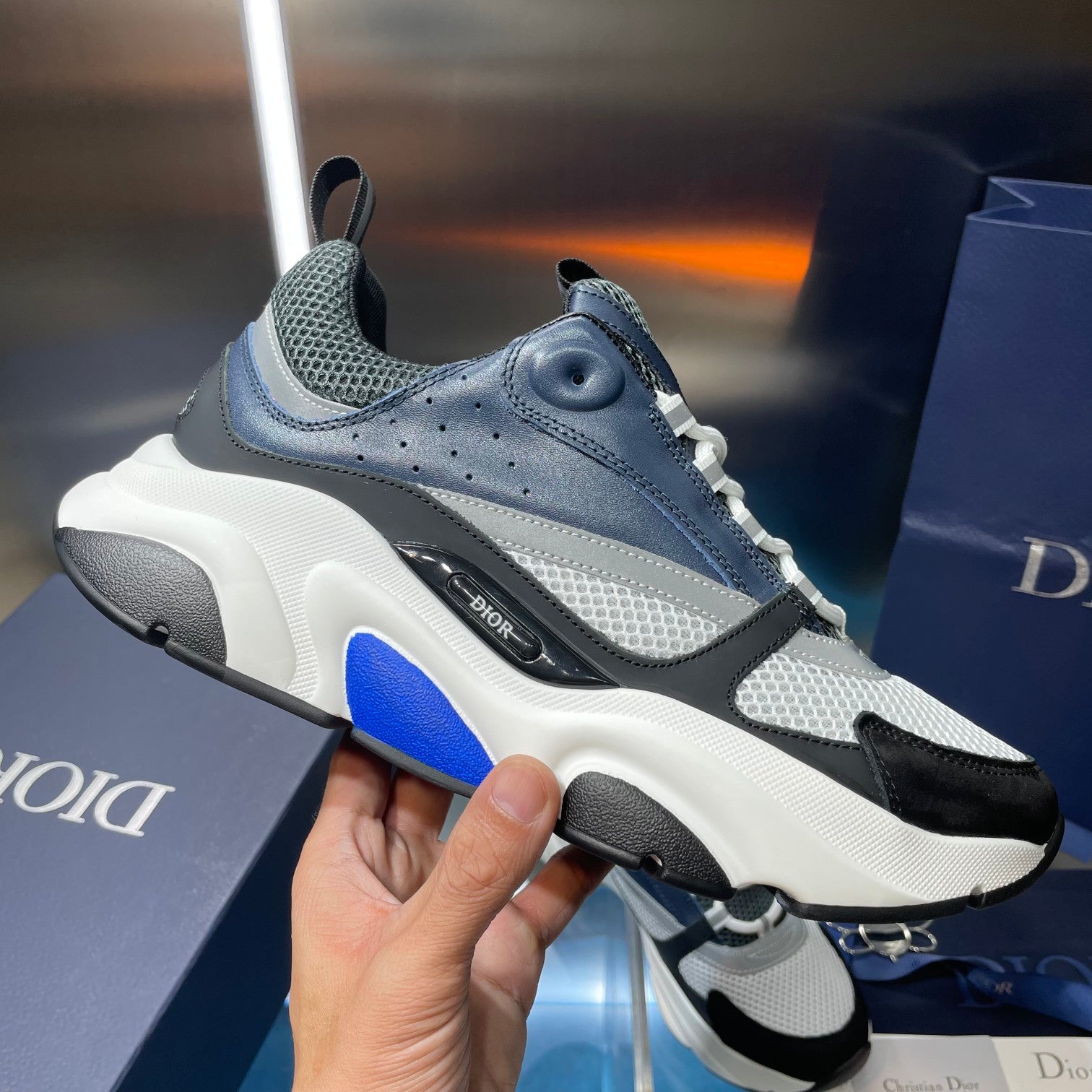 Blue-gray Dior sneakers with mesh upper, lace-up front, and white chunky sole
