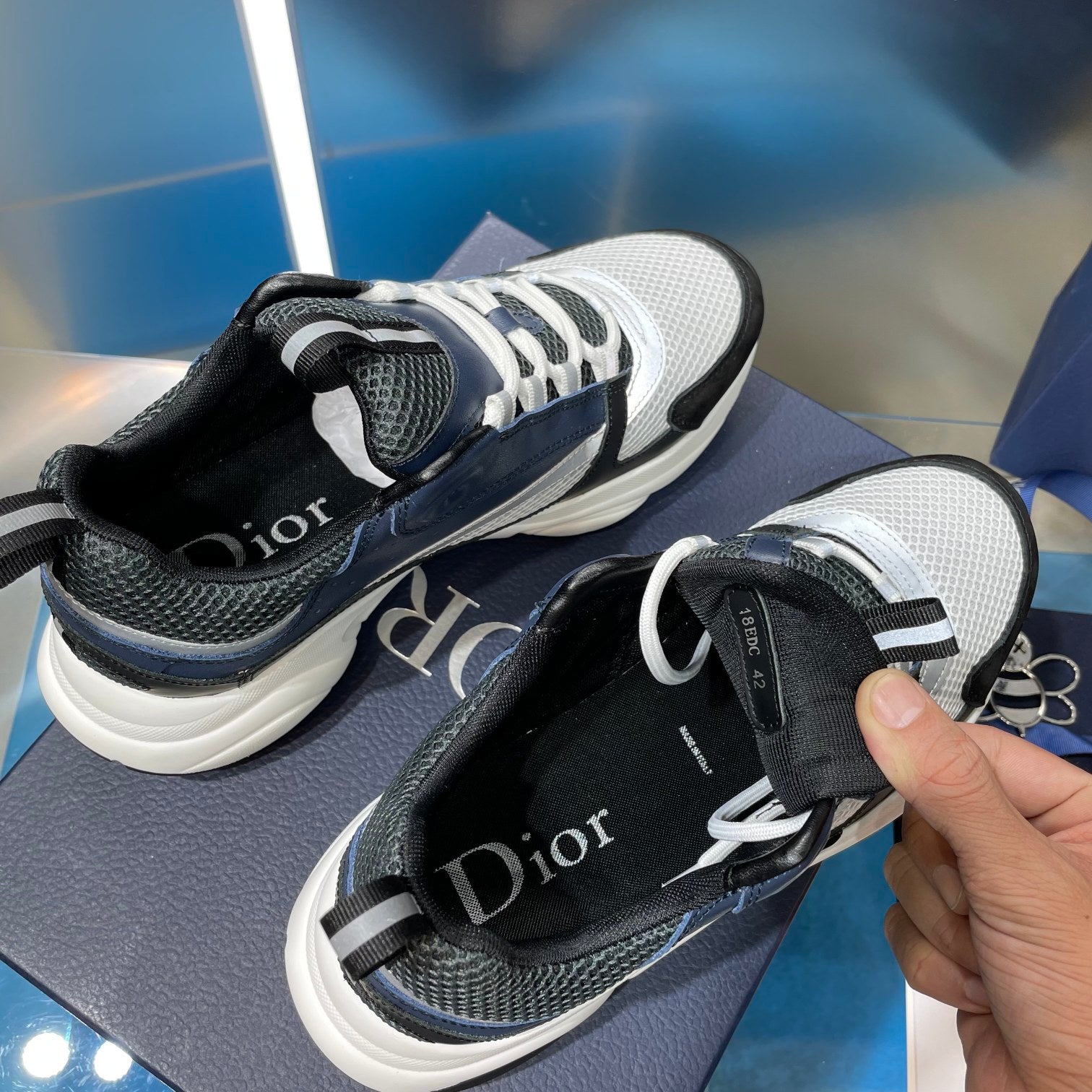 Dior sneakers with black heel, light gray toe, and lace-up knit upper