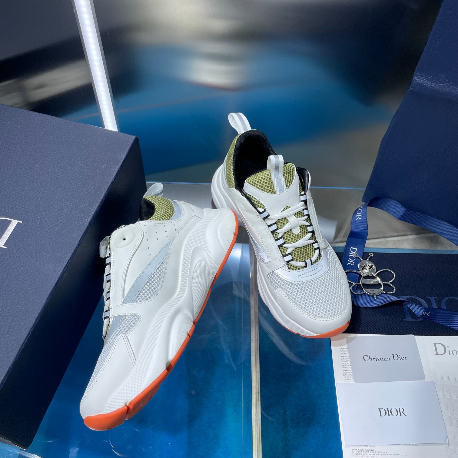 White lace-up sneakers with neon green lining and orange outsole edge