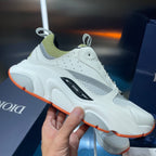 White low-top sneaker with neon green collar, black side stripe, orange outsole