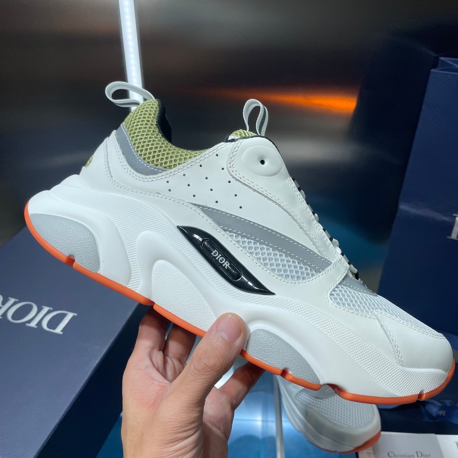 White low-top sneaker with neon green collar, black side stripe, orange outsole