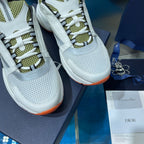 Close-up of white perforated sneaker uppers with neon green laces and orange sole