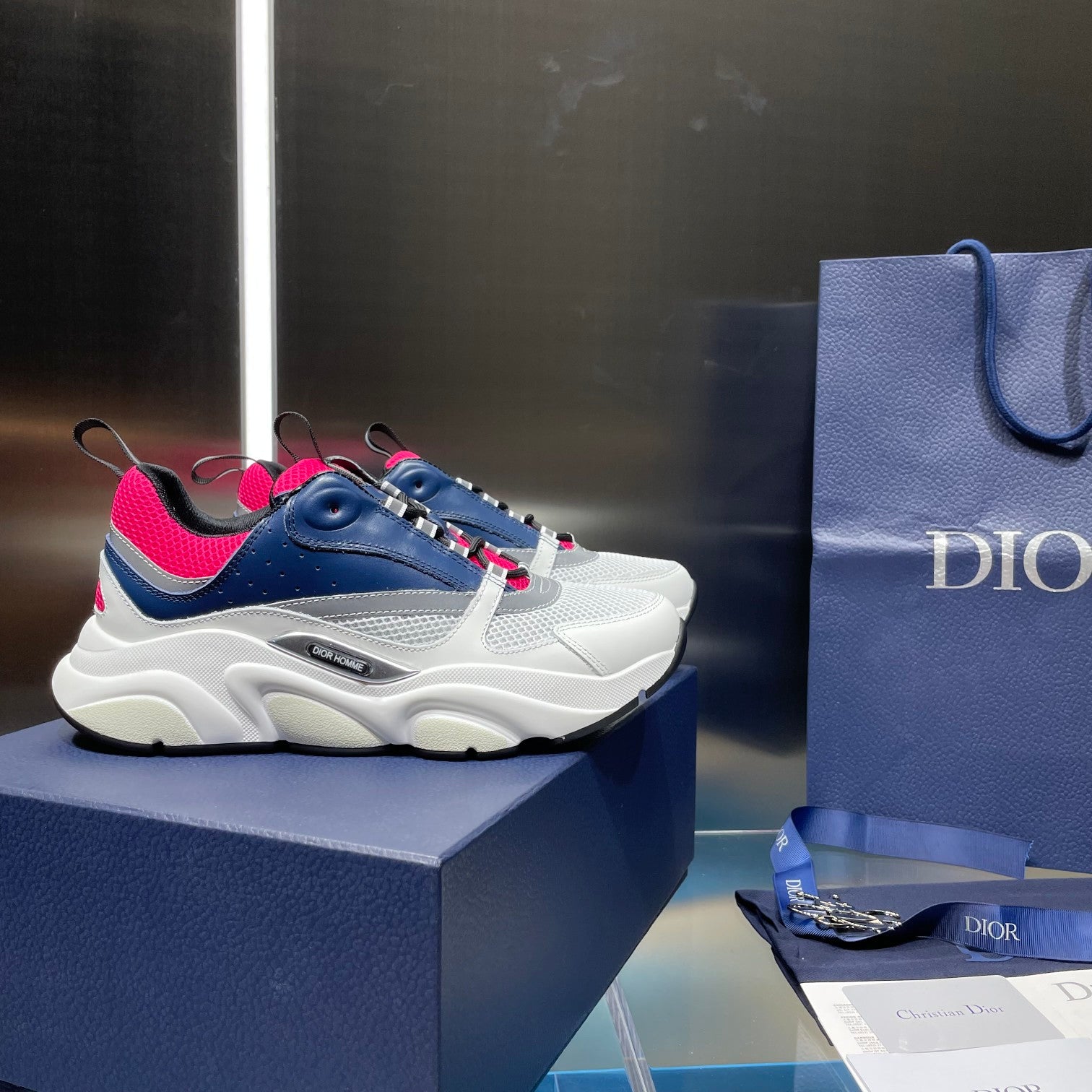 Lace-up sneakers in white and navy with bright pink accents on the side