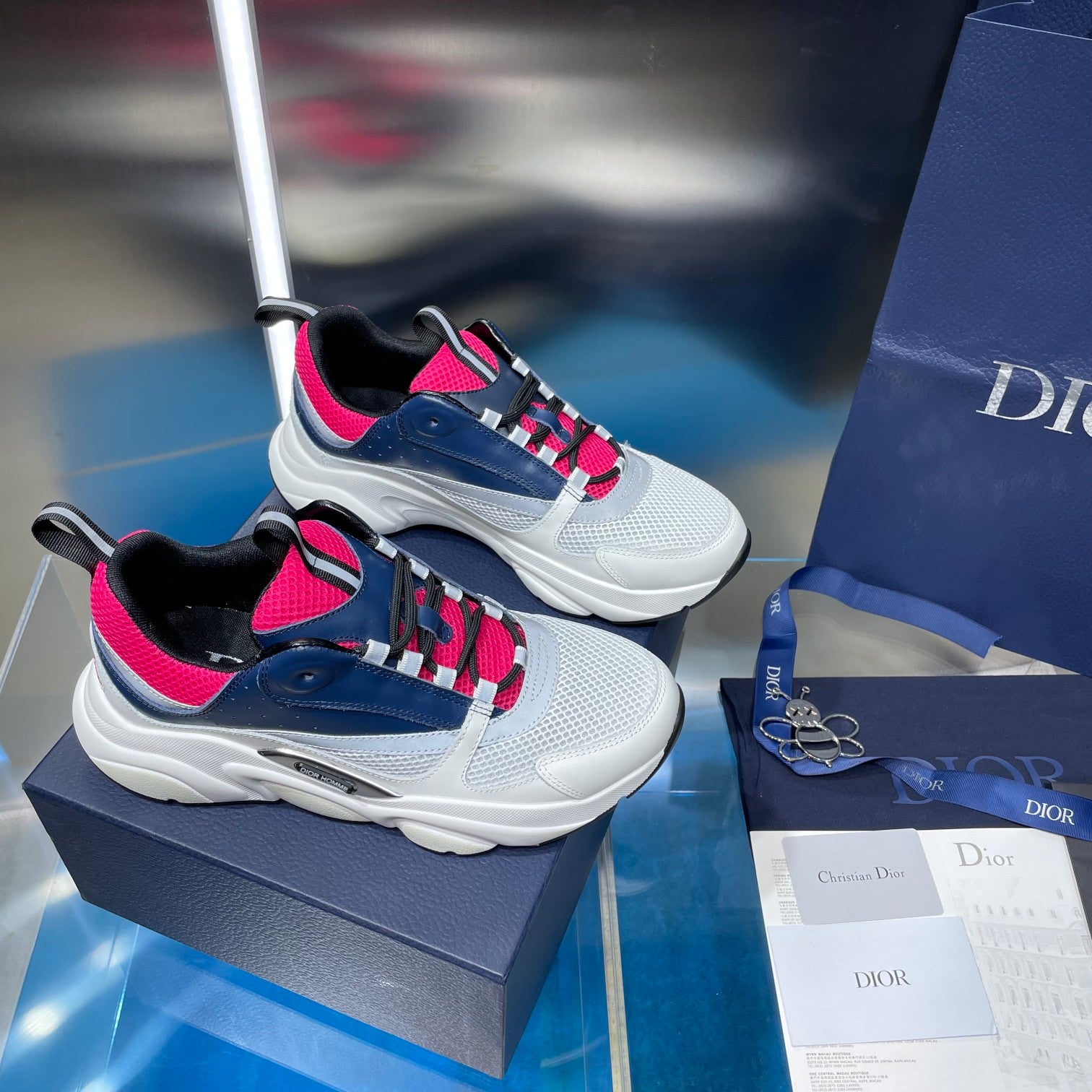 Pair of lace-up sneakers in white, navy and bright pink with black lining