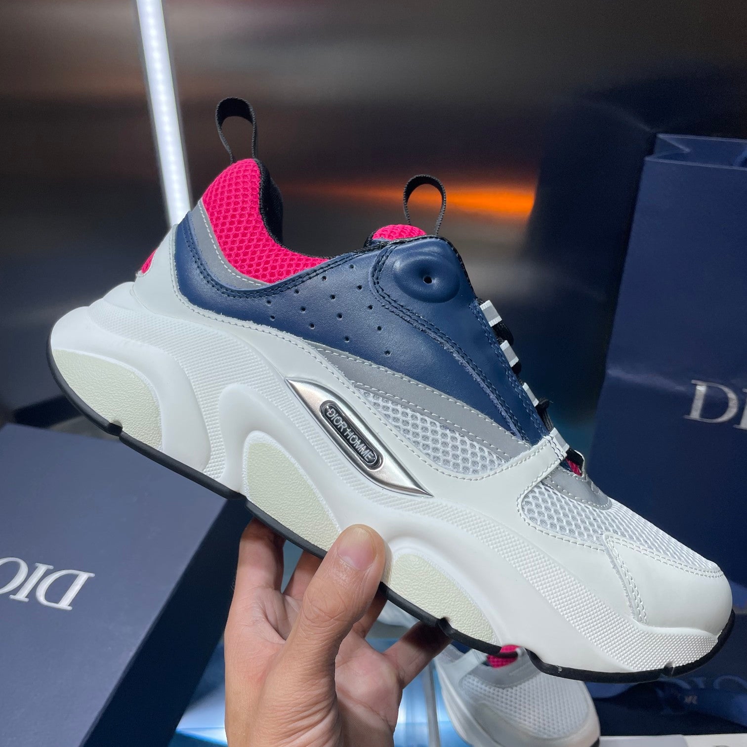 Side view sneaker in white mesh and navy leather with bright pink collar