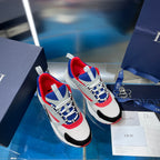 Two white sneakers with red accents and blue-and-white laces, on a box.