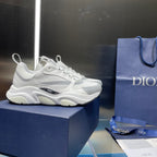 White lace-up sneaker on blue box, rounded toe and chunky sole