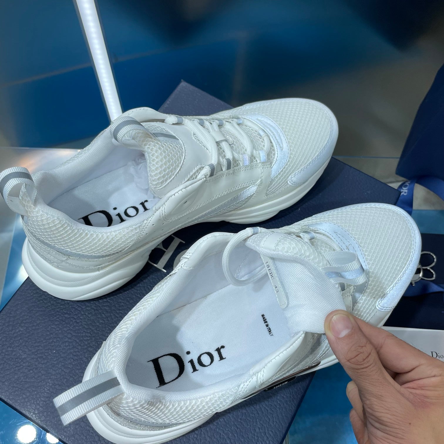White lace-up sneakers with logo on inner tongue and textured upper
