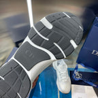 Sneaker outsole with dark tread and light sidewall, shown in close view