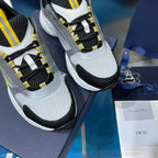 Close-up of unisex chunky sneakers, gray knit upper with black mesh and yellow laces