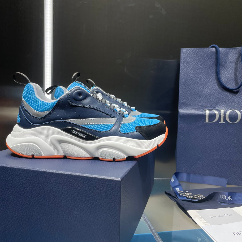 Dior unisex sneakers on dark box, blue upper, white sole, orange outsole
