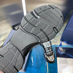 Outsole view of chunky sneakers with textured tread and embossed Dior initials