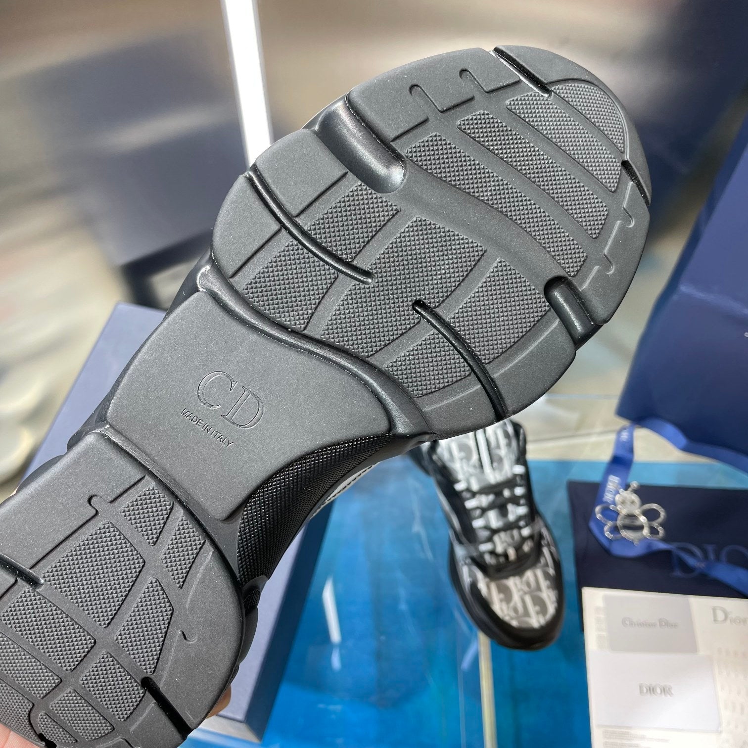 Outsole view of chunky sneakers with textured tread and embossed Dior initials