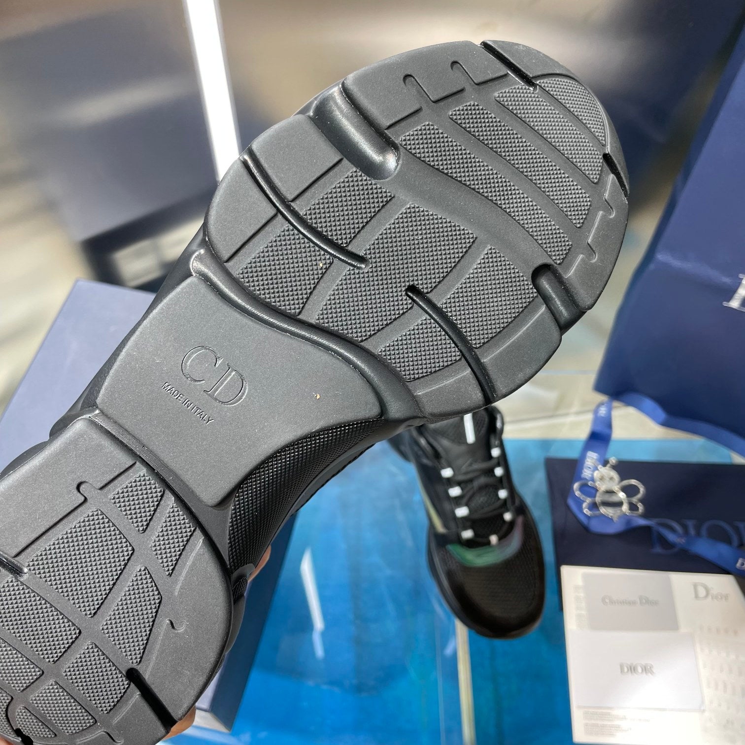 Black sneaker outsole with textured tread and Dior logo on heel cap