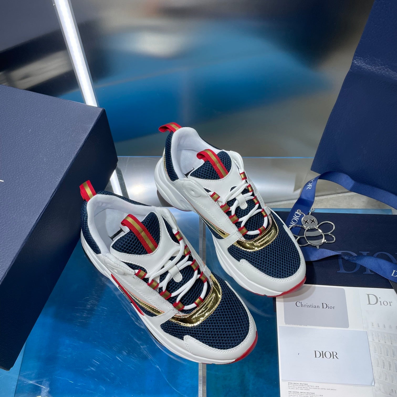 Dior unisex sneakers pair, white and navy with multicolor striped laces