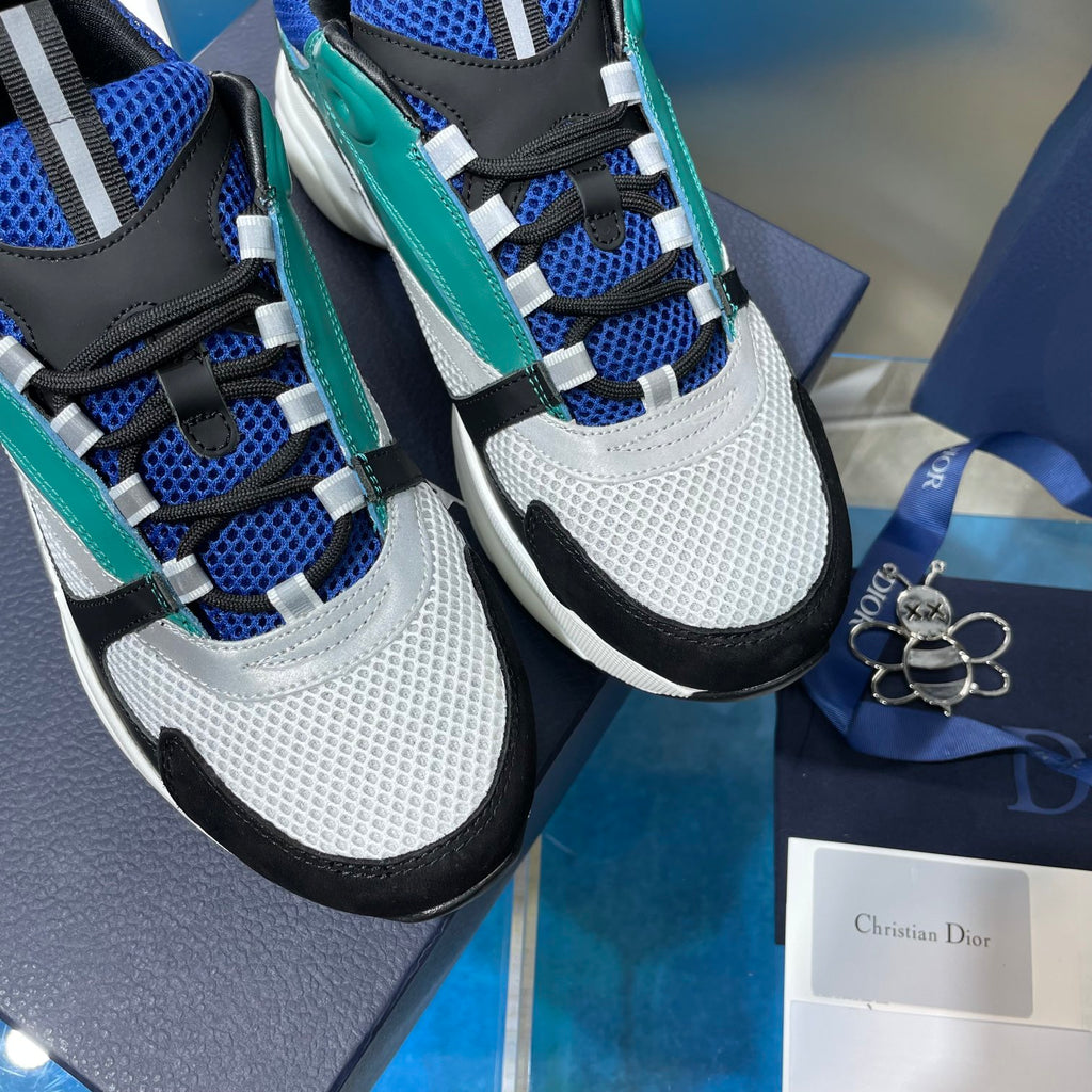Dior unisex sneakers close-up: white mesh toe, teal panels, blue laces, black accents