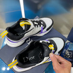 Dior sneakers with black and white uppers, purple stripe and yellow lace accents, chunky sole