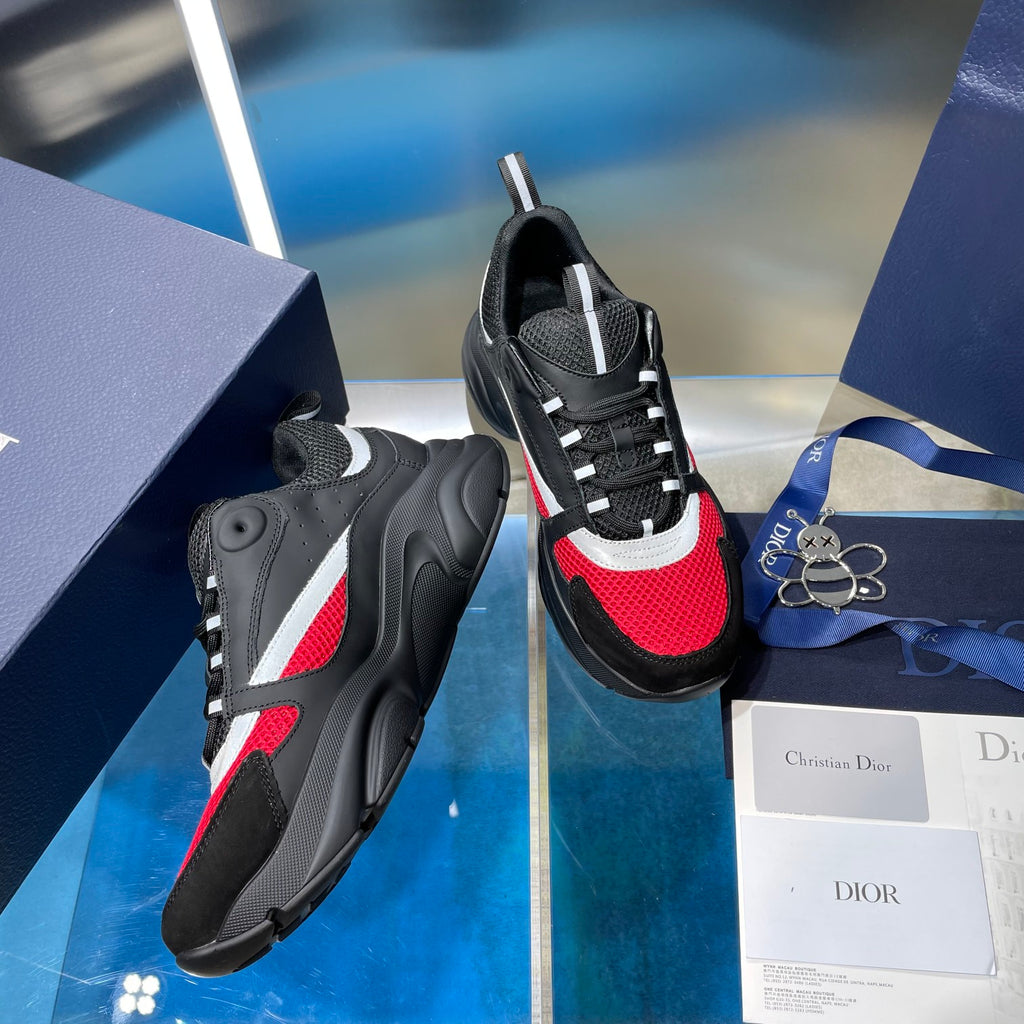 Unisex Dior lace-up sneakers pair, side view with black/red uppers and white stripe