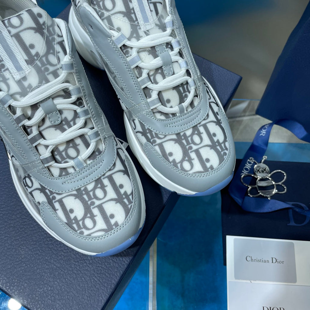 Dior unisex sneakers close-up: Dior Oblique logo panels, white laces, blue-trim sole