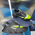 Chunky unisex sneakers, black with neon green panels and lace-up front.