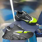 Chunky unisex sneakers, black with neon green panels and lace-up front.
