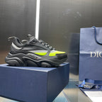 Low-top lace-up sneakers in dark gray with neon green side panels.