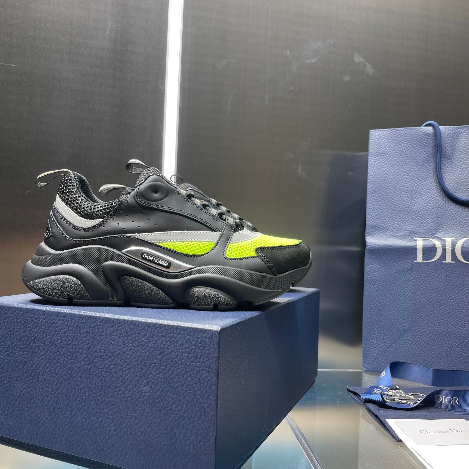 Low-top lace-up sneakers in dark gray with neon green side panels.