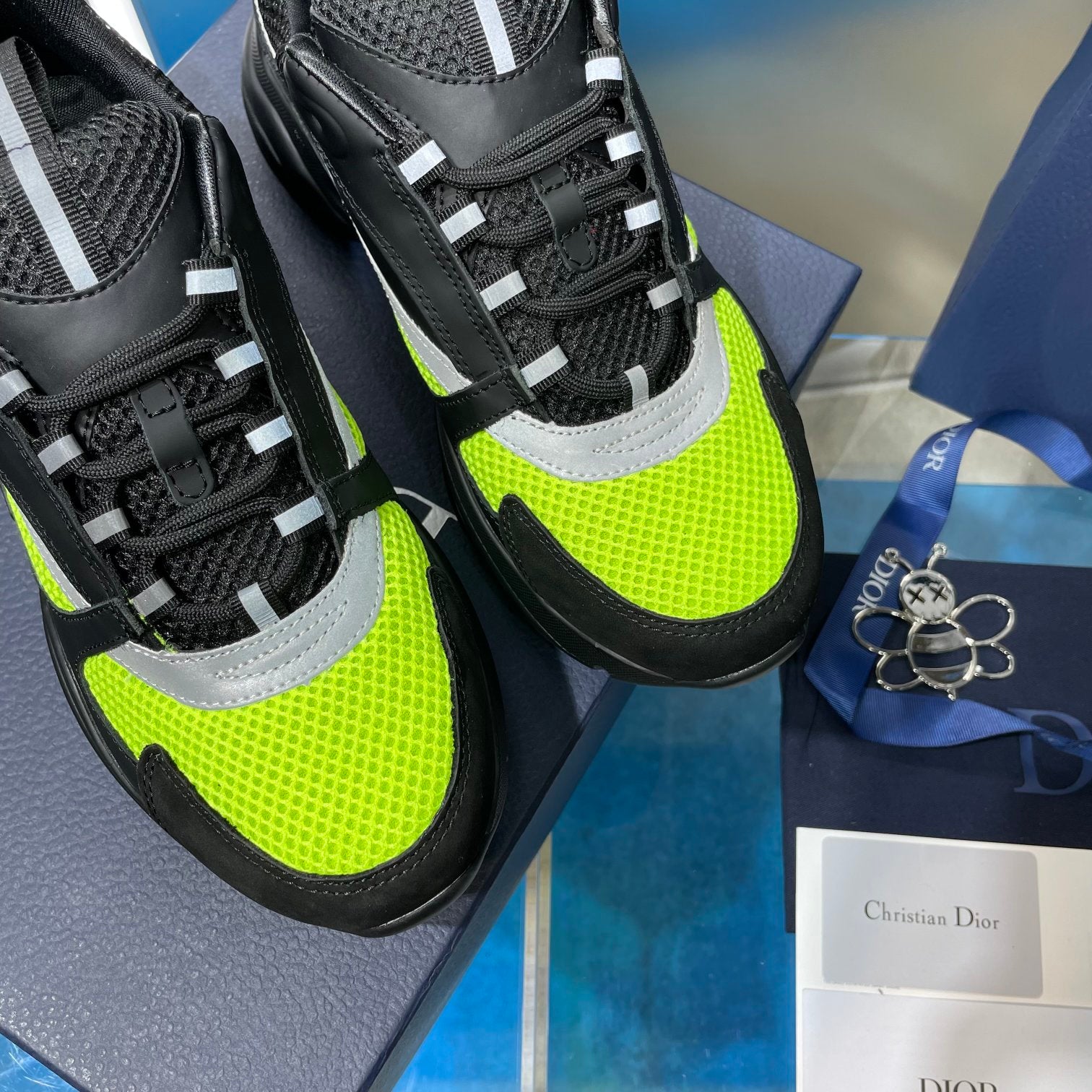 Close-up of chunky sneakers showing neon green uppers, mesh, and lace overlays.