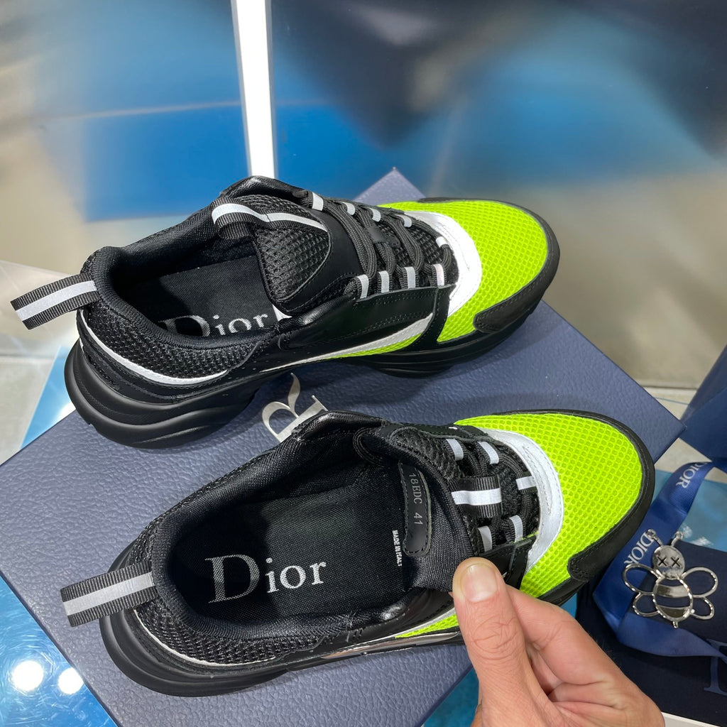 Sneakers with neon green uppers and black heel, plus adjustable strap across top.