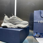 Unisex sneakers with light gray upper, gold laces, and chunky white midsole