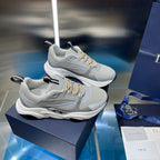 Unisex sneakers pair on display, light gray mesh with gold lace details