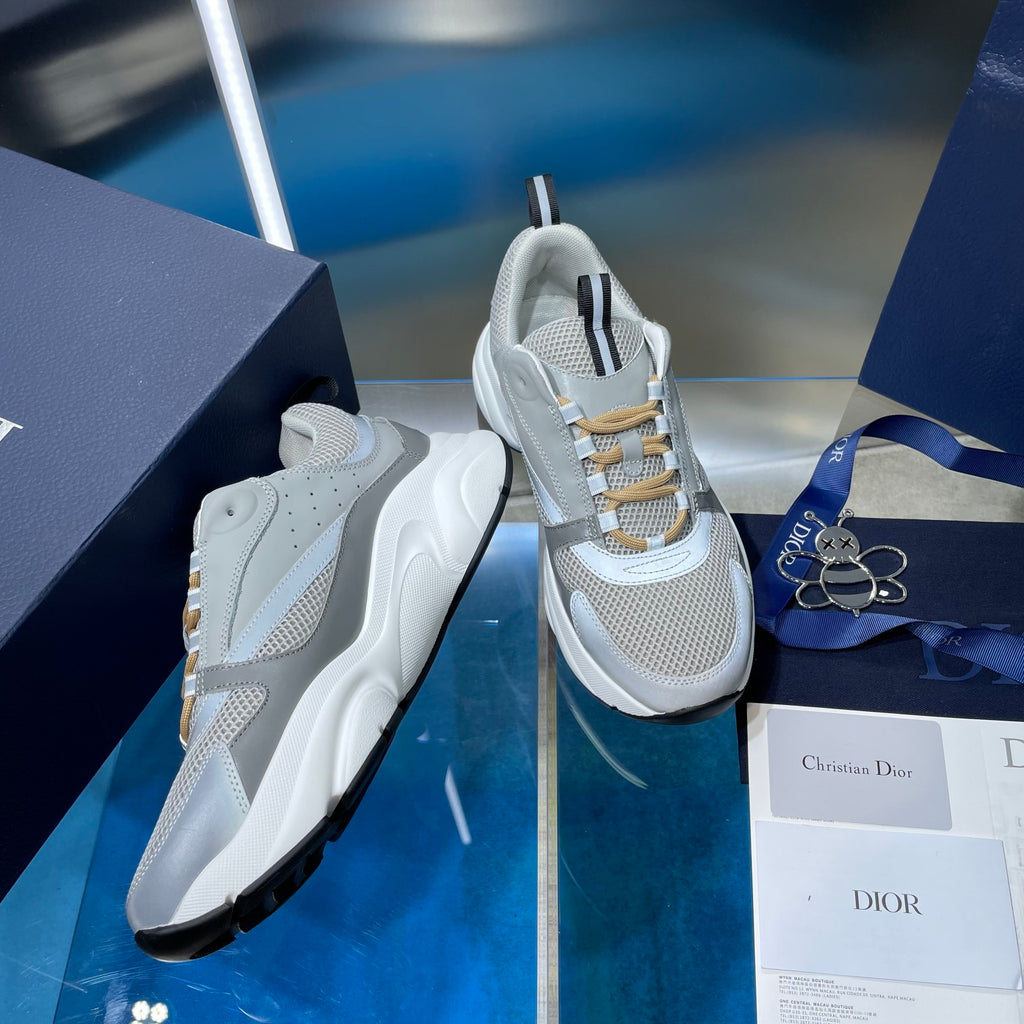 Unisex sneakers with perforated light gray mesh, gold laces, and striped heel tab