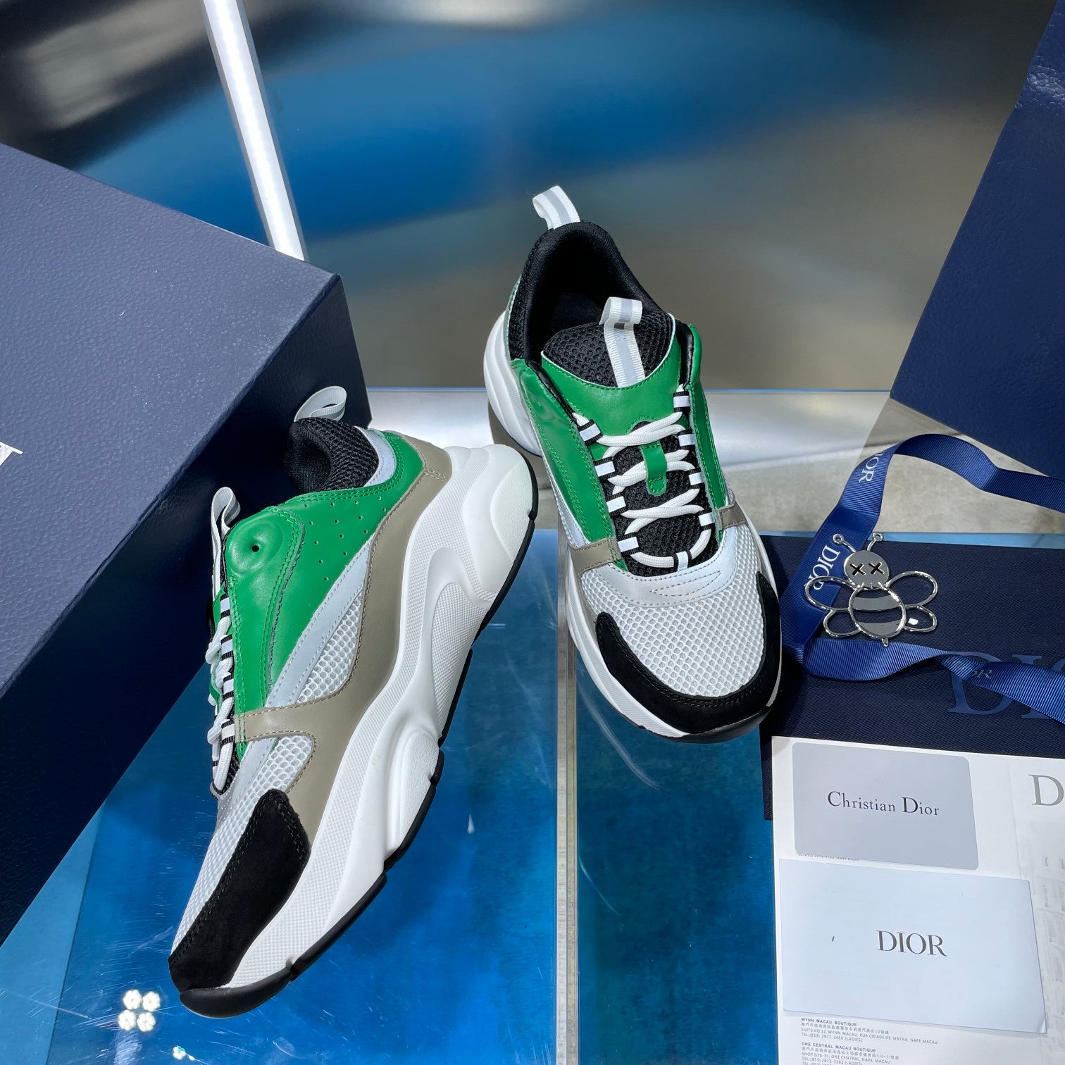 Pair of green and white lace-up sneakers with black heel and side panels