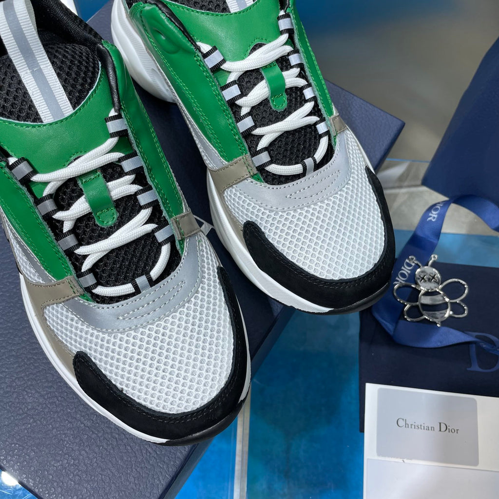 Close-up of green and white lace-up sneakers with black laces and textured uppers